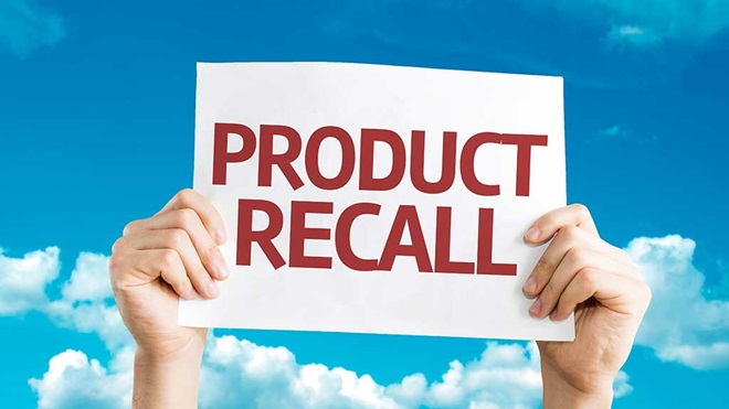 hands holding product recall sign